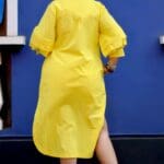 Model in Yellow Relaxed buttoned down dress posing back